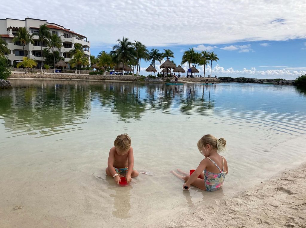 two kids playing in the water outside a resort